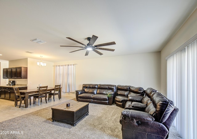 10856 E Primrose Ct, Florence, AZ 85132 - living room featuring light carpet, light tile patterned floors, visible vents, and ceiling fan with notable chandelier