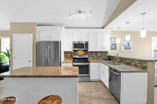 15391 W Yucatan Dr, Surprise, AZ 85379 - kitchen featuring appliances with stainless steel finishes, a sink, light wood-type flooring, tasteful backsplash, and white cabinetry