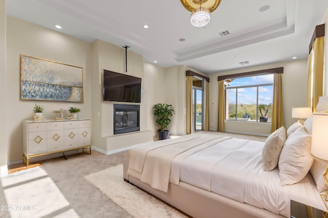 carpeted bedroom featuring a raised ceiling