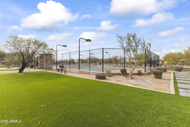 view of property's community featuring a lawn and tennis court