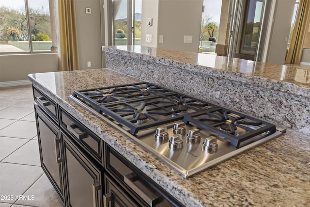 kitchen with light stone countertops, light tile patterned floors, and stainless steel gas cooktop