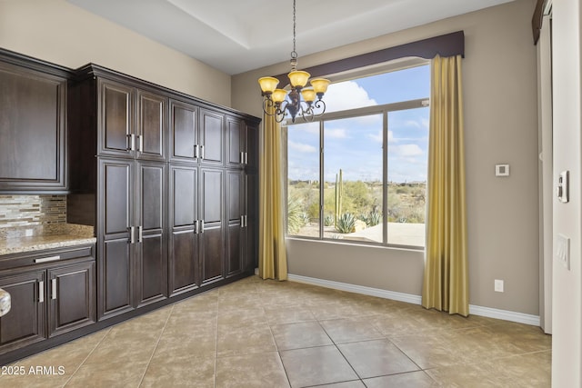 unfurnished dining area with light tile patterned floors and a chandelier