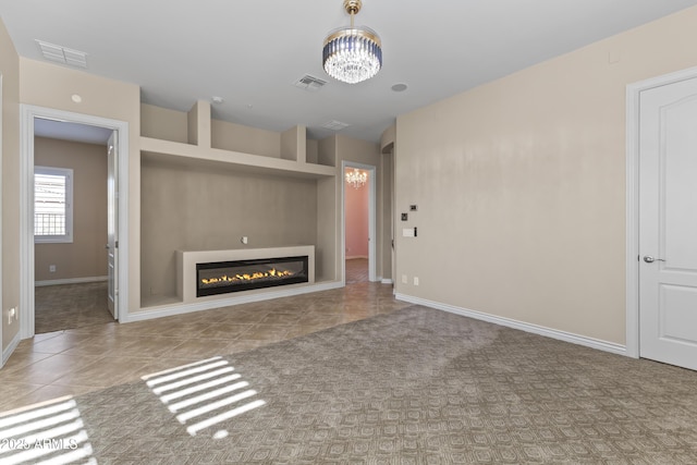 unfurnished living room with built in shelves, light tile patterned floors, and a notable chandelier