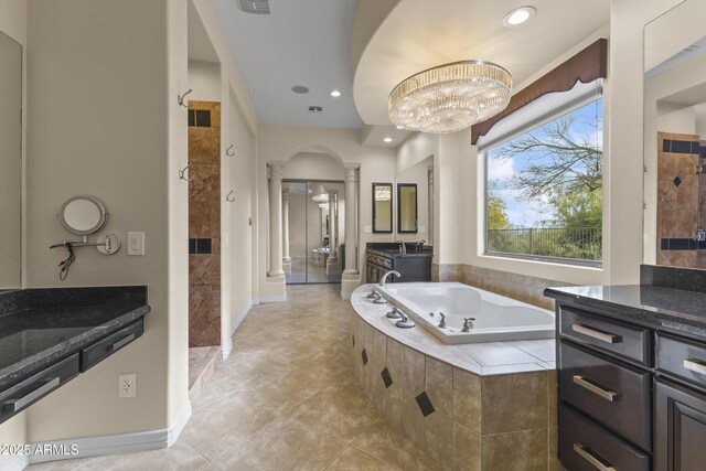 bathroom featuring decorative columns, tile patterned floors, vanity, a notable chandelier, and shower with separate bathtub