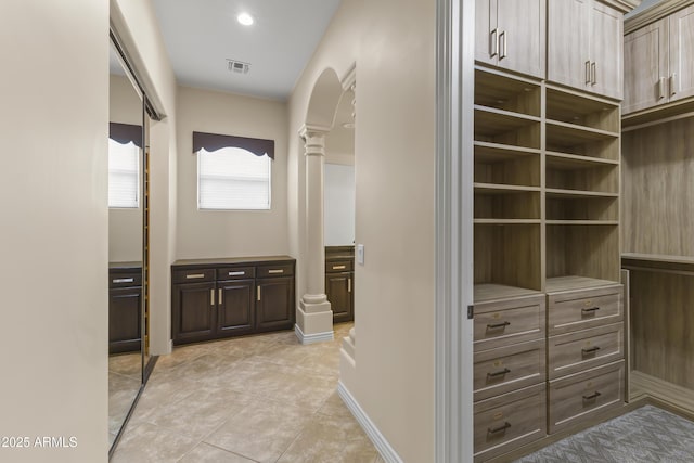 interior space featuring light tile patterned floors and decorative columns