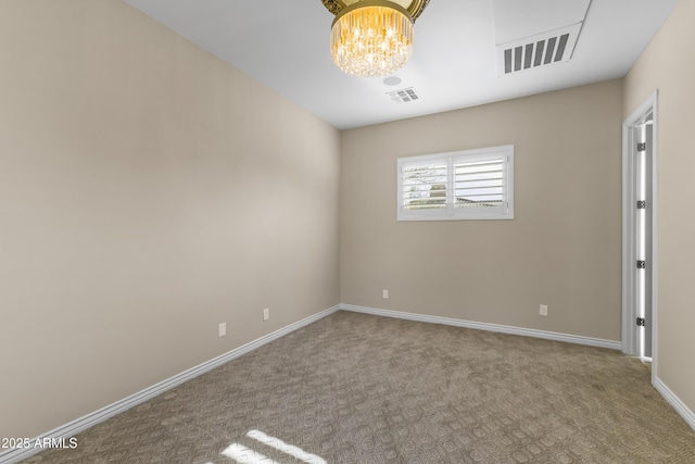 carpeted empty room featuring an inviting chandelier