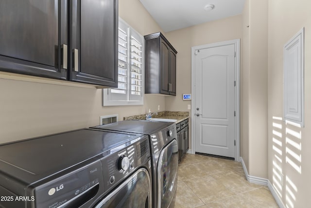 laundry room with cabinets, sink, washer and clothes dryer, and light tile patterned flooring