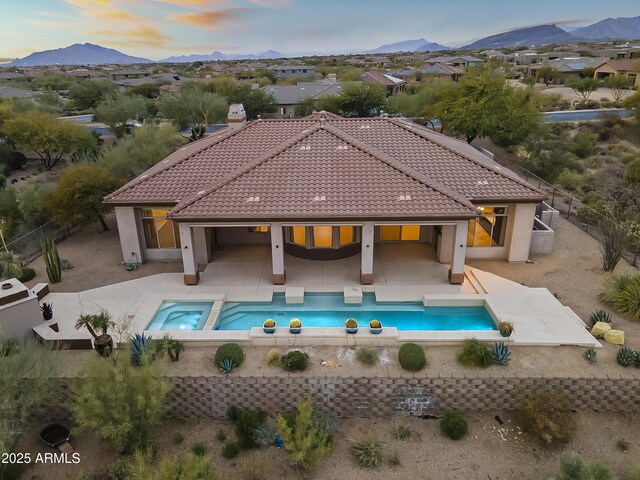 exterior space featuring a patio area, a mountain view, and an in ground hot tub