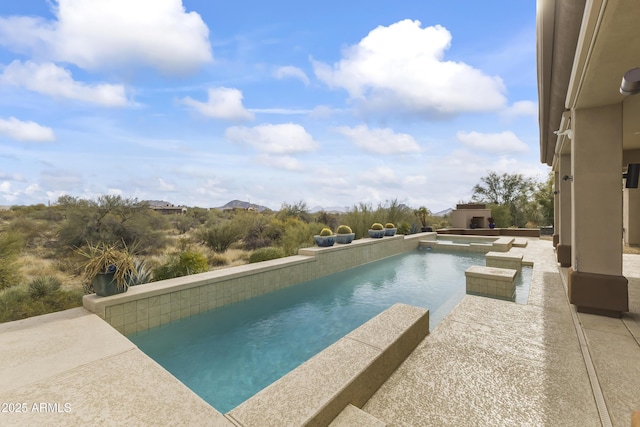 view of pool featuring a patio area and an in ground hot tub