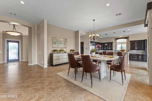 dining area featuring light tile patterned flooring and an inviting chandelier