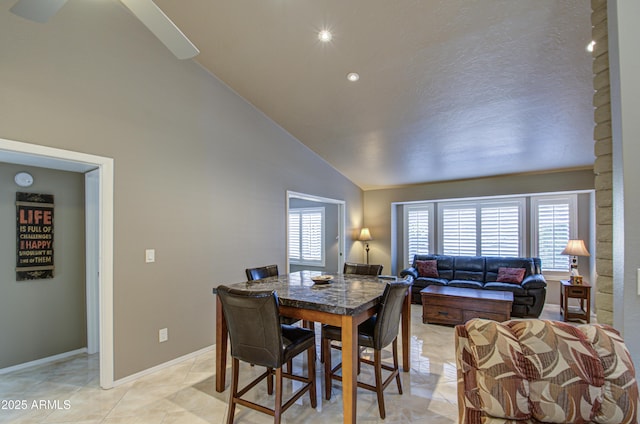 tiled dining area featuring high vaulted ceiling and a healthy amount of sunlight