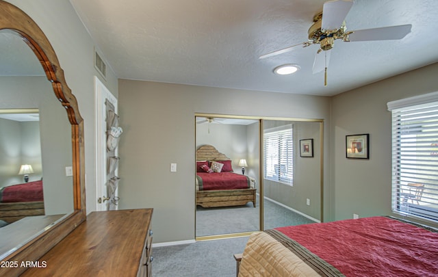 carpeted bedroom featuring multiple windows, a textured ceiling, and a closet