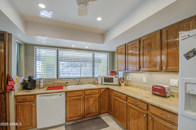 kitchen with sink, light tile patterned floors, ceiling fan, light stone counters, and white appliances