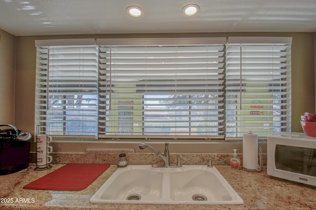 interior details with light stone countertops and sink