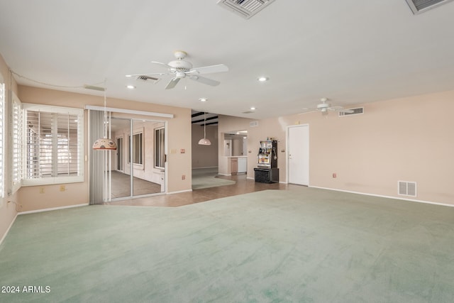 unfurnished living room featuring ceiling fan and carpet