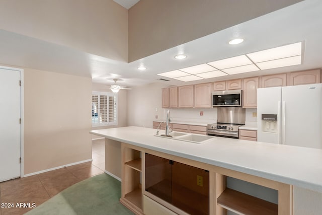 kitchen with stainless steel appliances, light tile patterned floors, light brown cabinets, sink, and ceiling fan