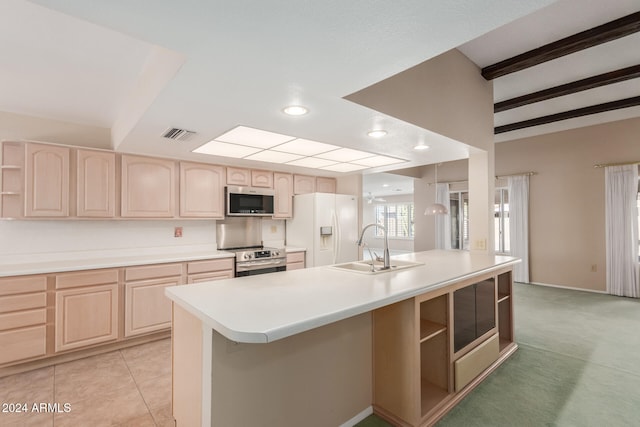 kitchen featuring light brown cabinets, appliances with stainless steel finishes, and an island with sink