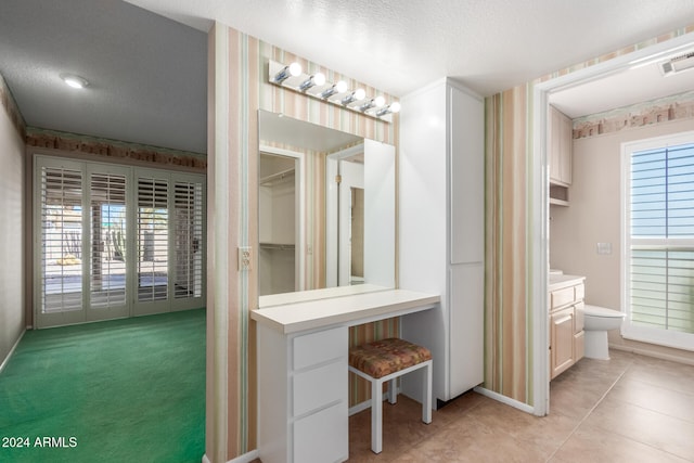 bathroom featuring tile patterned flooring, a textured ceiling, and toilet