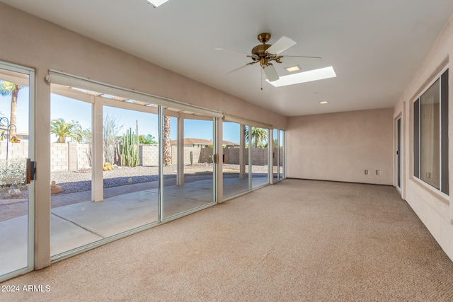 unfurnished sunroom with ceiling fan and a skylight