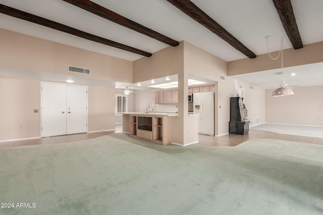 unfurnished living room featuring beamed ceiling, sink, light tile patterned floors, and ceiling fan