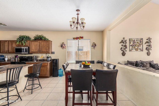 tiled dining room featuring a chandelier