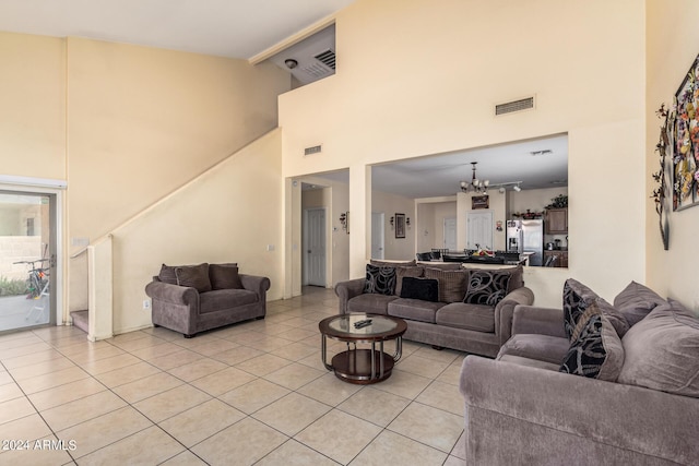 living room with high vaulted ceiling, light tile patterned floors, and an inviting chandelier