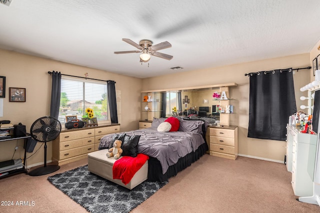 bedroom featuring a textured ceiling, carpet floors, and ceiling fan