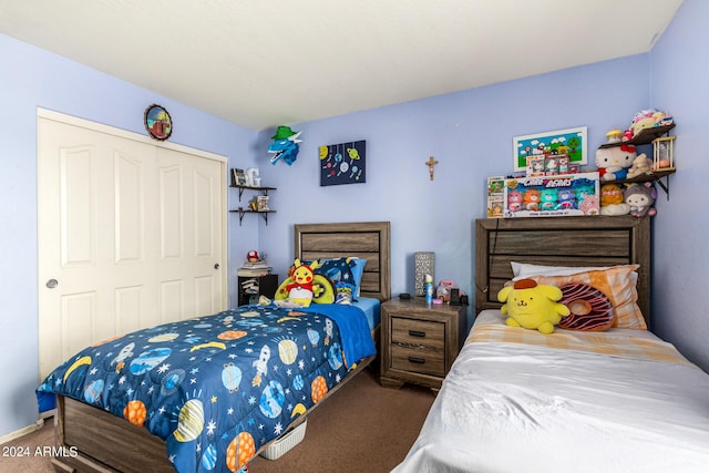 bedroom with dark carpet and a closet