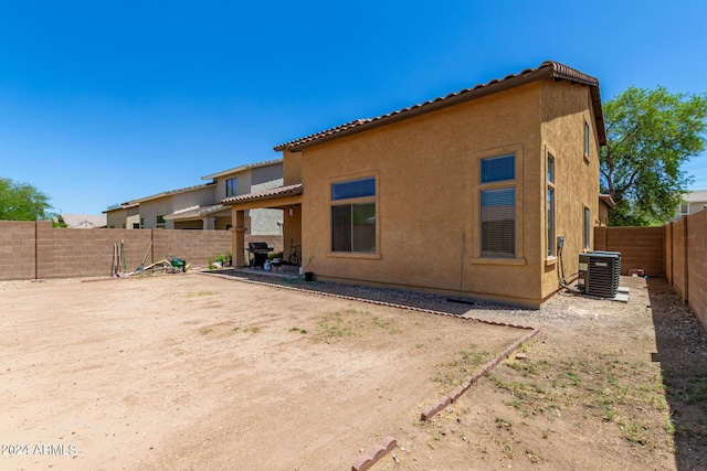 rear view of property featuring a patio and central air condition unit