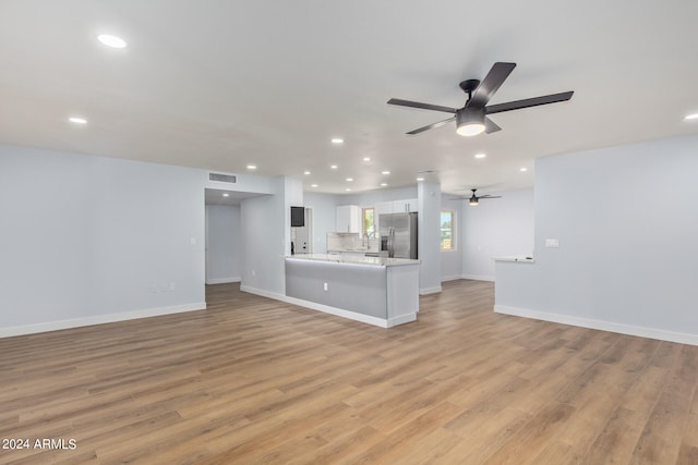 unfurnished living room with ceiling fan and light wood-type flooring