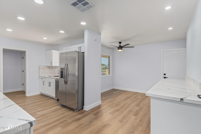 kitchen featuring appliances with stainless steel finishes, light stone counters, ceiling fan, light hardwood / wood-style floors, and white cabinetry