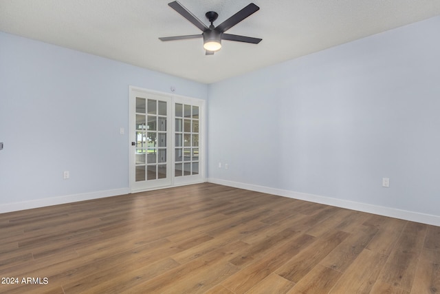 spare room with ceiling fan, french doors, and wood-type flooring