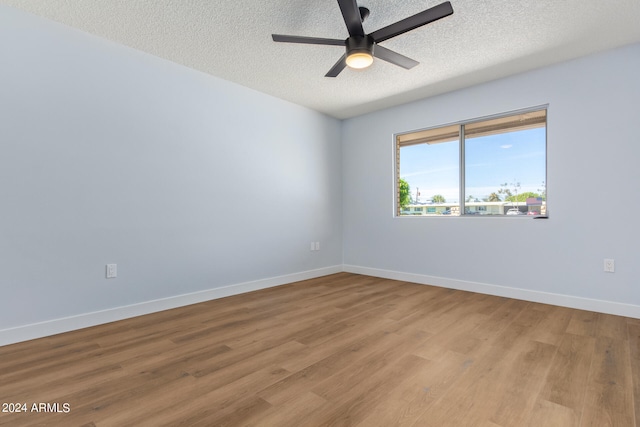 unfurnished room with a textured ceiling, ceiling fan, and light wood-type flooring