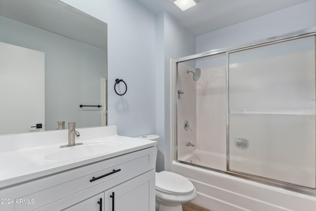 full bathroom with oversized vanity, toilet, and enclosed tub / shower combo