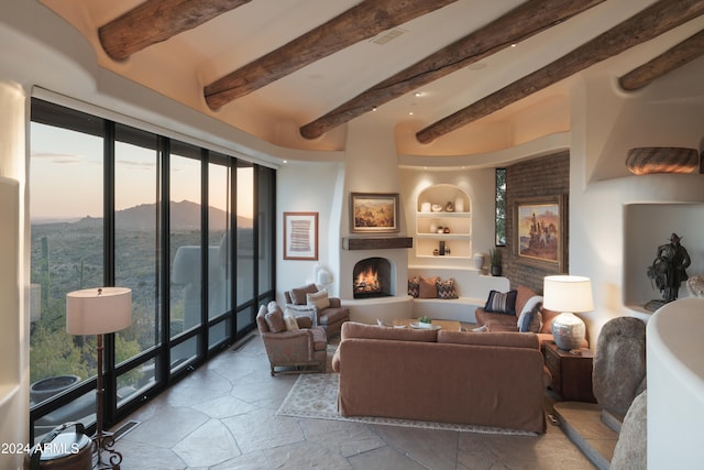 living room with beamed ceiling and built in shelves