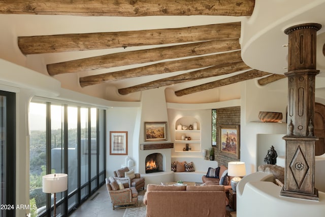 living room with a large fireplace, beam ceiling, and built in shelves