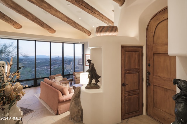 living room featuring beam ceiling, a mountain view, and plenty of natural light