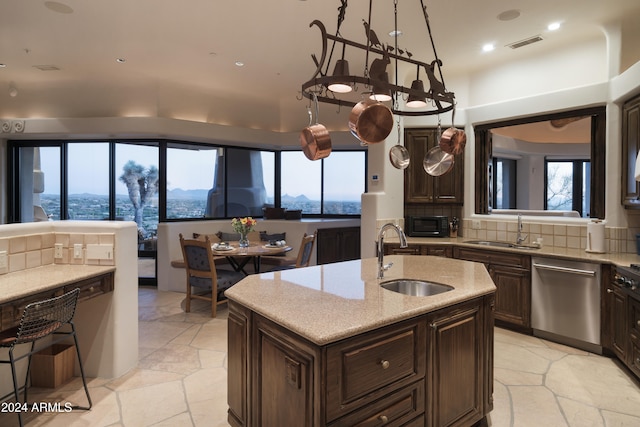 kitchen featuring decorative backsplash, a healthy amount of sunlight, stainless steel dishwasher, and sink