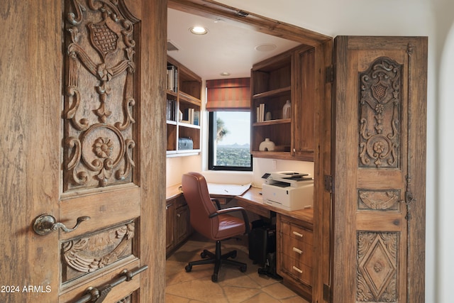 office area with built in desk and light tile patterned flooring