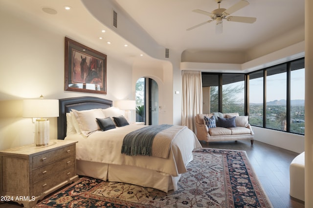 bedroom with a mountain view, hardwood / wood-style flooring, and ceiling fan