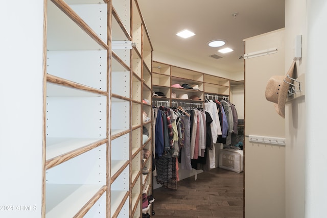 walk in closet with dark wood-type flooring