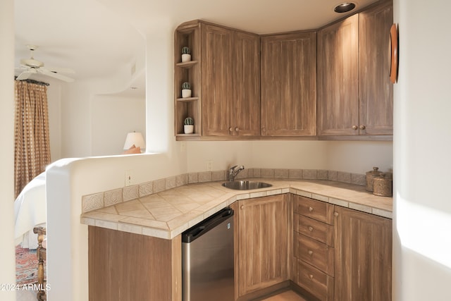 kitchen with tile countertops, stainless steel dishwasher, sink, and ceiling fan