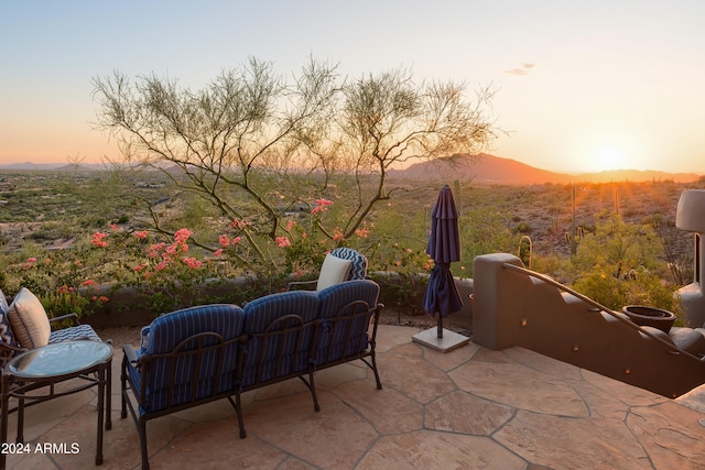 patio terrace at dusk featuring a mountain view