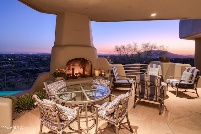 patio terrace at dusk featuring an outdoor living space with a fireplace