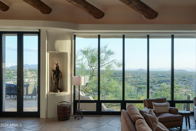 sunroom with beamed ceiling and a mountain view