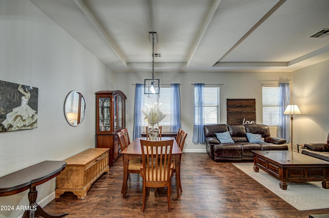 dining space with dark hardwood / wood-style floors and a tray ceiling