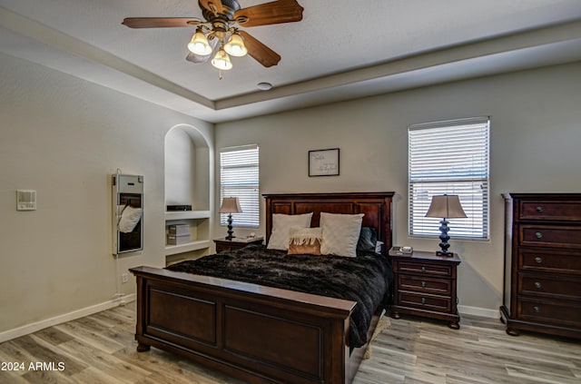 bedroom with multiple windows, ceiling fan, and light wood-type flooring