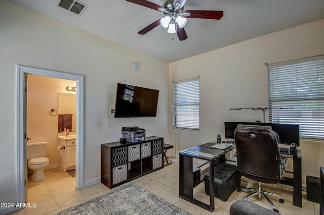 home office featuring ceiling fan, sink, and light tile patterned floors