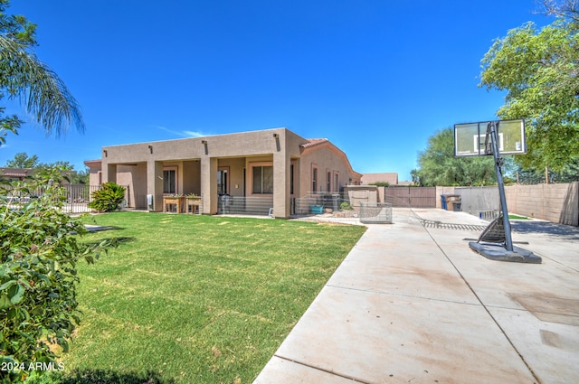 back of house with a yard and a patio