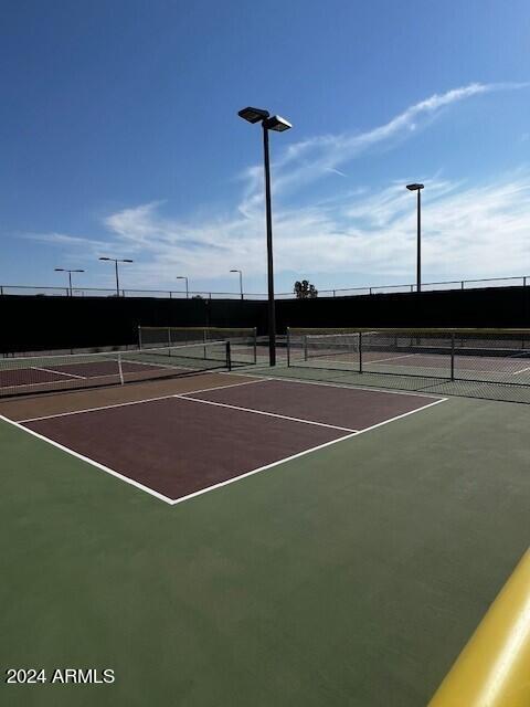 view of tennis court with basketball hoop